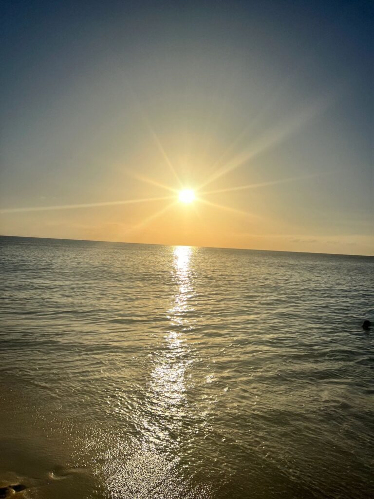 Golden sun reflecting on calm ocean horizon